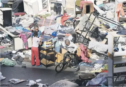  ?? Picture: Nigel Sibanda ?? CHAOS. A mother and child outside Fattis Mansions in Johannesbu­rg yesterday after spending a night out in the cold after being evicted from a hijacked building. The building, dubbed ‘Mnyamandaw­o’, on the corner of Jeppe and Harrison streets, has no...