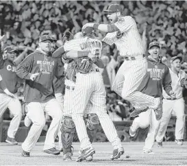  ?? Jamie Squire / Getty Images ?? The Cubs mob closer Aroldis Chapman after he completed the shutout of the Dodgers and sent Chicago into the World Series against Cleveland.