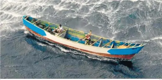 ?? EFE ?? La imagen cedida por el Ejército del Aire muestra a los tres supervivie­ntes del cayuco que naufragó en El Hierro, sentados en la popa, a la izquierda.
