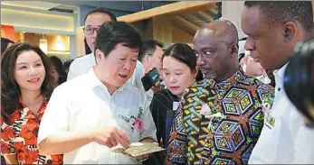  ?? PHOTOS PROVIDED TO CHINA DAILY ?? Xu Xiangping (center), head of the Hunan Provincial Department of Commerce, takes part in the opening ceremony of the African cafe strip in Changsha in August.