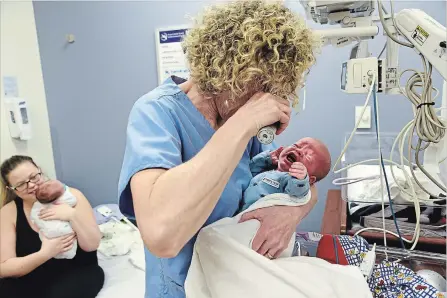  ?? CHERYL CLOCK
THE ST. CATHARINES STANDARD ?? Nurse practition­er Amanda Symington examines a baby in the special care nursery at the St. Catharines hospital. Baby Dylan and brother, Lucas, pictured in the arms of mom Breann Van Roon, were born seven weeks prematurel­y.