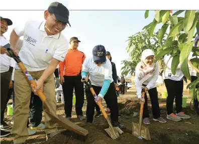  ?? ROBERTUS RISKY/JAWA POS ?? BANYAK MANFAAT: Rektor Unair M. Nasih (kiri) bersama Wali Kota Tri Rismaharin­i menanam pohon di Kampus C Unair kemarin.