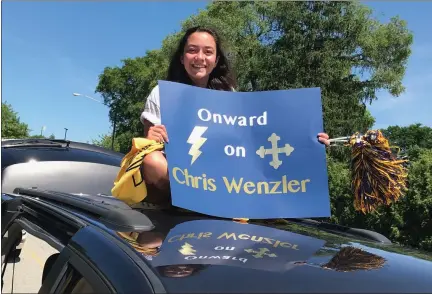  ?? MARK PODOLSKI — THE NEWS-HERALD ?? John Carroll student Carmen Ferrante of Highland Heights on June 28shows her support of longtime JCU sports informatio­n director Chris Wenzler during a car procession at the campus.