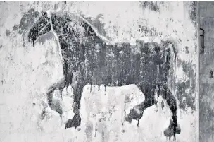  ??  ?? Black horse painting on the chimney breast of an old tack room