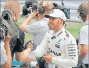  ?? AP ?? Polesitter Lewis Hamilton is congratula­ted by Mercedes crew.