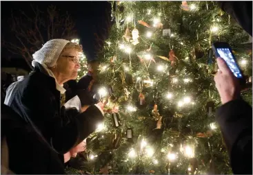  ?? RECORDER PHOTOS BY CHIEKO HARA ?? Elizabeth Carper looks for her son’s ornament Tuesday at the 23rd annual Myers Memorial Tree lighting ceremony at Myers Funeral Service and Crematory. Her son passed away a week ago.