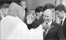  ?? AFP/Getty Images ?? SAUDI CROWN PRINCE Mohammed bin Salman, left, greets Russian President Vladimir Putin at the Group of 20 summit in Buenos Aires last week.