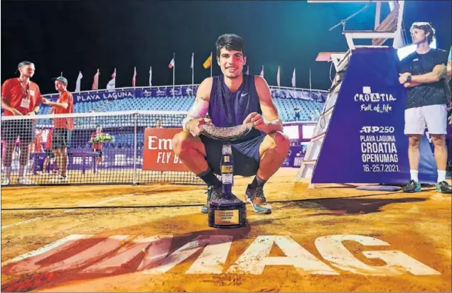  ??  ?? Carlos Alcaraz posa con el trofeo de campeón del torneo ATP 250 de Umag, su primer título en el circuito a sus 18 años.