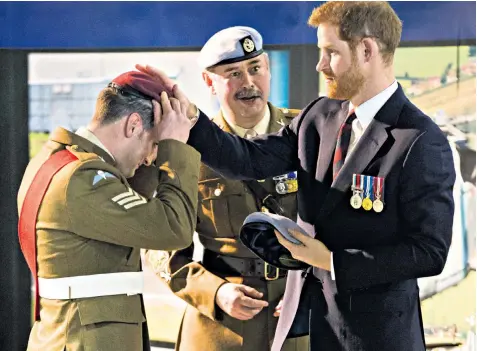  ??  ?? Prince Harry exchanges Sgt Mathew Marshall’s red para beret for a blue Army Air Corps one at the Middle Wallop military base, where he presented pilots with their wings