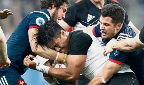  ?? — AP ?? Surrounded: New Zealand’s Julian Savea (centre) is tackled by France’s Maxime Machenaud (left) and Brice Dulin during their Test match at the Stade de France in Paris on Saturday.