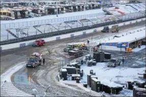  ?? AP PHOTO/MATT BELL ?? Titan Track Dryers work to clear the track at Martinsvil­le Speedway in Martinsvil­le, Va., Sunday, March 25, 2018. The NASCAR Cup Series race at Martinsvil­le Speedway was postponed until Monday because of inclement weather.