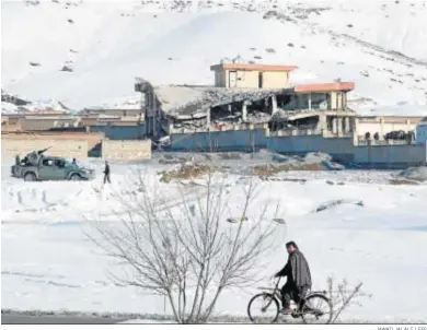  ?? JAWAD JALALI / EFE ?? Un hombre pasea en bicicleta junto al edificio atacado ayer de la principal agencia de seguridad afgana en Wardak.