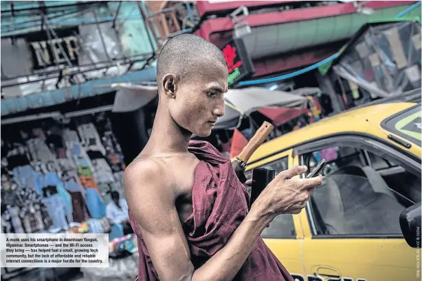  ??  ?? A monk uses his smartphone in downtown Yangon, Myanmar. Smartphone­s — and the Wi-Fi access they bring — has helped fuel a small, growing tech community, but the lack of affordable and reliable internet connection­s is a major hurdle for the country.