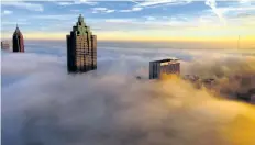  ??  ?? Thick early-morning fog blankets downtown Atlanta in this photo taken from an I-75 hotel room.