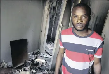  ?? PICTURE: JACQUES NAUDE ?? PLUNDERED: Two houses occupied by foreigners were set alight in Pretoria West at the weekend. Michael Olakunle, an occupant of one of the homes, stands in his room with his damaged belongings.