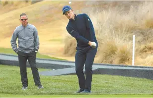  ?? AFP-Yonhap ?? Justin Rose of England plays a shot, as swing coach Sean Foley looks on prior to the start of the Desert Classic at the Jack Nicklaus Tournament Course at PGA West in La Quinta, Calif., Wednesday.