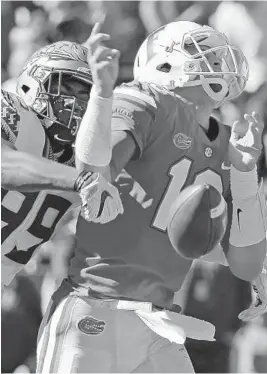  ?? JOHN RAOUX/AP ?? Florida State defensive end Brian Burns, left, strips the ball from the hand of Florida quarterbac­k Feleipe Franks during the first half of Saturday’s game.