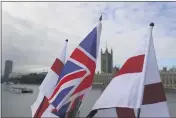 ?? KIRSTY WIGGLESWOR­TH — THE ASSOCIATED PRESS ?? English flags and a Union flag fly above a souvenir stand opposite Britain’s Parliament in London on Friday.