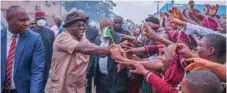  ??  ?? Governor Ikpeazu shaking hands with jubilant students during the Immaculate road inaugurati­on