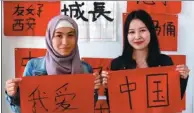  ?? REN QI / CHINA DAILY ?? Eurasian University students Zhuassova Assem (left) and Gazizova Guldana show on Thursday their Chinese calligraph­y works, which together say “I Love China”.