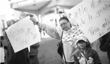  ??  ?? Protesters block the entrance to a gas station as they take part during a demonstrat­ion against the rising prices of gasoline enforced by the Mexican government at Tlalpan avenue in Mexico City, Mexico Jan 3. The placard reads “Pena out. PRI out”,...