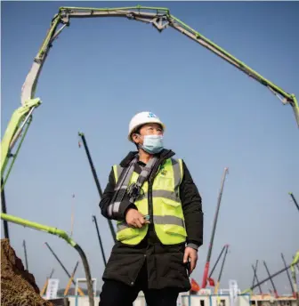  ??  ?? Yuan Tianxiong at the constructi­on site of Huoshensha­n Hospital. Born and raised in Wuhan where the coronaviru­s outbreak was first reported, Yuan saw the hospital sprout from nothing.