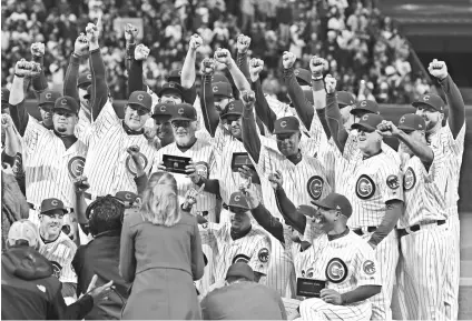  ?? MATT MARTON, AP ?? Members of the 2016 Cubs come together for a group photo after being presented with their World Series championsh­ip rings April 12 at Wrigley Field.