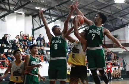  ?? Photo by Jean Nicole Cortes ?? NO EASY SHOT. Two players of UC Jaguars gang up on a BCT Atoms during their second round match – up in the Baguio-Benguet Educationa­l Athletic League (BBEAL) at the UC gym.