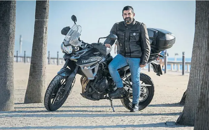  ?? ANA JIMÉNEZ ?? Chakir el Homrani, con su moto, una Triumph Tiger de 800 cc, en el paseo marítimo del Bogatell, en Barcelona, cerca del Departamen­t de Treball, Afers Socials i Famílies, que dirige
