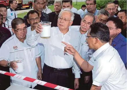  ?? PIC BY YAZIT RAZALI ?? Prime Minister Datuk Seri Najib Razak looking at the ‘Effluent Reuse Facility’ water sample after launching the Pantai 2 Sewage Treatment Plant and Pantai Eco Park yesterday in Kuala Lumpur. Present are Energy, Green Technology and Water Minister Datuk...