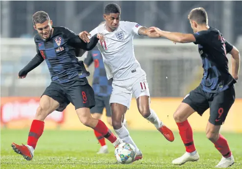  ??  ?? England’s Marcus Rashford, center, vies for the ball with Croatia’s Mateo Kovacic, left, and Duje Cop.