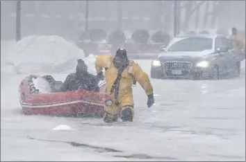  ?? John Cetrino EPA/Shuttersto­ck ?? BOSTON Firefighte­r Justin Plaza pulls a motorist to dry land. Cars were stuck in floodwater­s throughout the city. Tides in Boston Harbor equaled levels recorded during the historic blizzard of 1978. In Quincy, Mass., the mayor said: “The city has been...