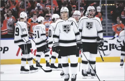  ?? JEFF MCINTOSH/THE CANADIAN PRESS VIA AP ?? Los Angeles Kings right wing Dustin Brown, center, looks away as the Edmonton Oilers celebrate after winning Game 7 of a first-round series in the NHL hockey Stanley Cup playoffs on Saturday in Edmonton, Alberta.