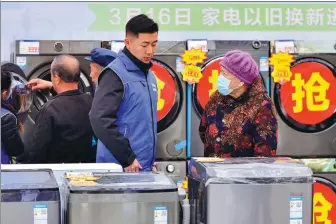  ?? WANG JILIN / FOR CHINA DAILY ?? A shopper (right) seeks informatio­n on products displayed at a home appliance sales promotion event in Qingzhou, Shandong province.