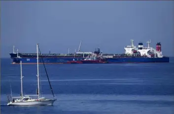  ?? Thanassis Stavrakis/Associated Press ?? A sailboat passes near the Pegas tanker, which until recently was named Lana, in the foreground and surrounded by other vessels Friday off the port of Karystos on the Aegean Sea island of Evia, Greece.