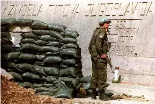  ?? (AFP/Getty) ?? A UN Protection Force so l dier next to an inscriptio­n reading ‘Long Live Tito' s Yugos l avia’, 29 March 1994