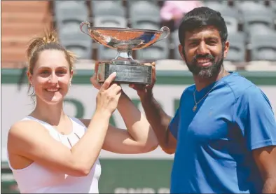  ?? The Associated Press ?? Canada’s Gabriela Dabrowski and India’s Rohan Bopanna hold the trophy as they celebrate winning their mixed doubles final match against Anna-Lena Groenefeld of Germany and Robert Farah of Colombia in two sets 2-6, 6-2 (12-10) at the French Open in...