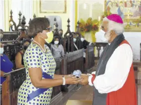  ??  ?? Retired Bishop of Kingston Robert Thompson receives the rolled scroll of his citation from Ambassador Alison Stone-roofe, on behalf of the diocese, at the service of appreciati­on for his years of ministry to the Anglican Diocese of Jamaica and the Cayman Islands on Sunday at the Cathedral of St Jago de la Vega in Spanish Town.
