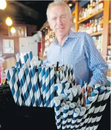  ?? GREG GILBERT, SEATTLE TIMES ?? Duke Moscrip, owner of Duke’s Restaurant­s in Seattle, with an assortment of paper straws. Businesses that sell food or drinks won’t be allowed to offer the plastic items under a rule that went into effect Sunday.