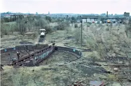  ?? IAN WINDSCHEFF­EL ?? The turntable being recovered from Ashford in 1982, with the preserved Bulleid double-deck EMU just visible outside the former steam shed.