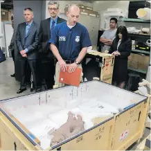  ?? SINCO KELLEHER/ THE ASSOCIATED PRESS
JENNIFER ?? Brenton Easter, with Homeland Security Investigat­ions, inspects artifacts in the basement of the Honolulu Museum of Art on Wednesday.