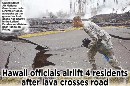  ??  ?? United States Air National Guardsman John Linzmeier looks at cracks on the ground as toxic gases rise nearby in the Leilani Estates subdivisio­n near Pahoa on Friday.