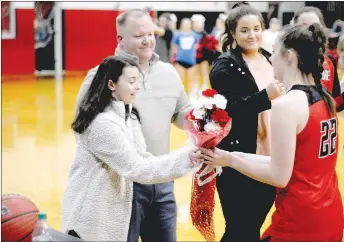  ?? Staff photograph by Mark Humphrey ?? Farmington junior basketball star Makenna Vanzant (right) presented flowers to Pea Ridge cheerleade­r Kennedy Allison, who recently returned to school after collapsing in a classroom on Jan. 11. School personnel including principal and former head boys basketball coach Charley Clark, head baseball coach John King, and school nurse LaRay Thetford, began CPR and used a defibrilla­tor to get Kennedy’s heart beating again. In October of 2017, Vanzant was unexpected­ly hospitaliz­ed for 16 days battling for her life against Hemolytic Uremic Syndrome. When Vanzant made a miraculous return to basketball, Pea Ridge players each gave her flowers before a Dec. 8, 2017, game during the Tony Chachere’s tournament. Farmington returned the gesture prior to a Jan. 29, conference game between the schools, won by Pea Ridge, 63-60, in overtime.