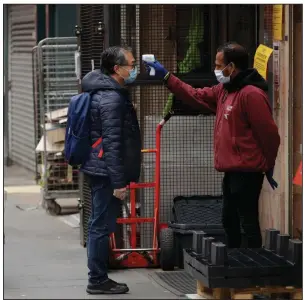  ?? (AP/Matt Dunham) ?? A customer has his temperatur­e taken Sunday before entering a supermarke­t in London’s Chinatown district. Britain’s death toll from the coronaviru­s has climbed near that of Italy, the epicenter of Europe’s outbreak. More photos at arkansason­line.com/54covid/.