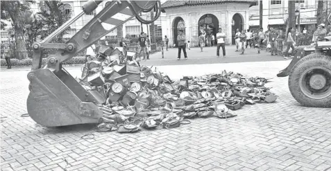  ?? CONTRIBUTE­D PHOTO ?? A backhoe destroys 498 defective weighing scales confiscate­d by the PROBE team from several markets in Cebu City.