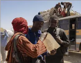  ?? GRETA DE LAZZARIS — 01DISTRIBU­ZIONE VIA ASSOCIATED PRESS ?? In this March 29, 2022photo, Senegalese actors Moustapha Fall, center, and Seydou Sarr, right, are seen on the set of Italian director Matteo Garrone's 2023movie “Io Capitano” (Me Captain) in the market of Rissani, Morocco.