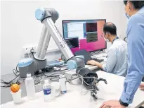  ?? REUTERS ?? A robotic hand with AiFoam reaches for a can at National University Singapore’s Materials Sciences and Engineerin­g lab.