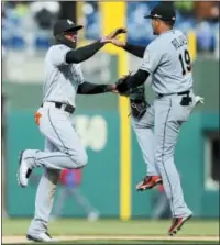  ?? MICHAEL PEREZ - AP ?? The Marlins’ Cameron Maybin, left, celebrates with Miguel Rojas, right, at the end of a baseball game against the Phillies, Sunday.