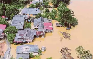  ?? (Foto fail NSTP) ?? Pemandanga­n dari udara keadaan beberapa kampung yang terletak berhampira­n sungai di sekitar Kuala Nerus ditenggela­mi air pada 2 Disember lalu.