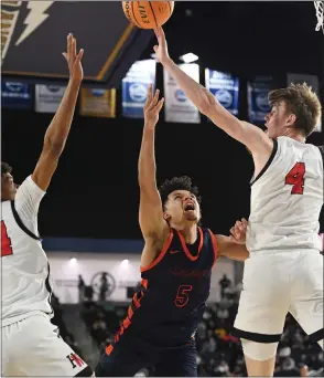  ?? PHOTO BY MILKA SOKO ?? Roosevelt’s Brayden Burries attacks the basket between Harvard-westlake’s Isaiah Carroll and Nikolas Khamenia during the CIF Southern Section Open Division boys basketball title game Friday.
